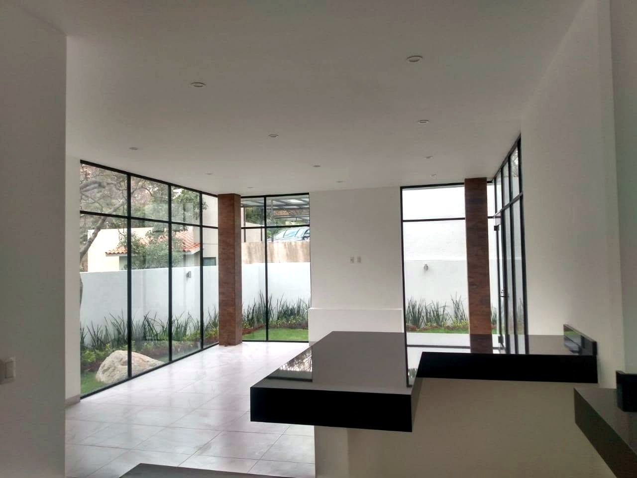 Sala con muros de cristal y columnas de tabique, Residencia CDMX