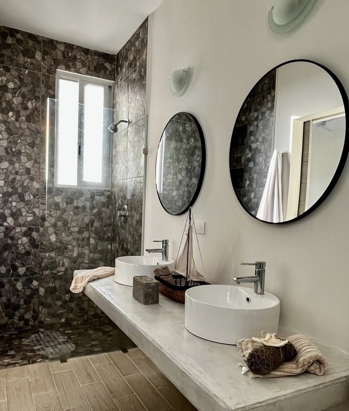Baño con doble lavabo y muro de piedra, Casa Cielo